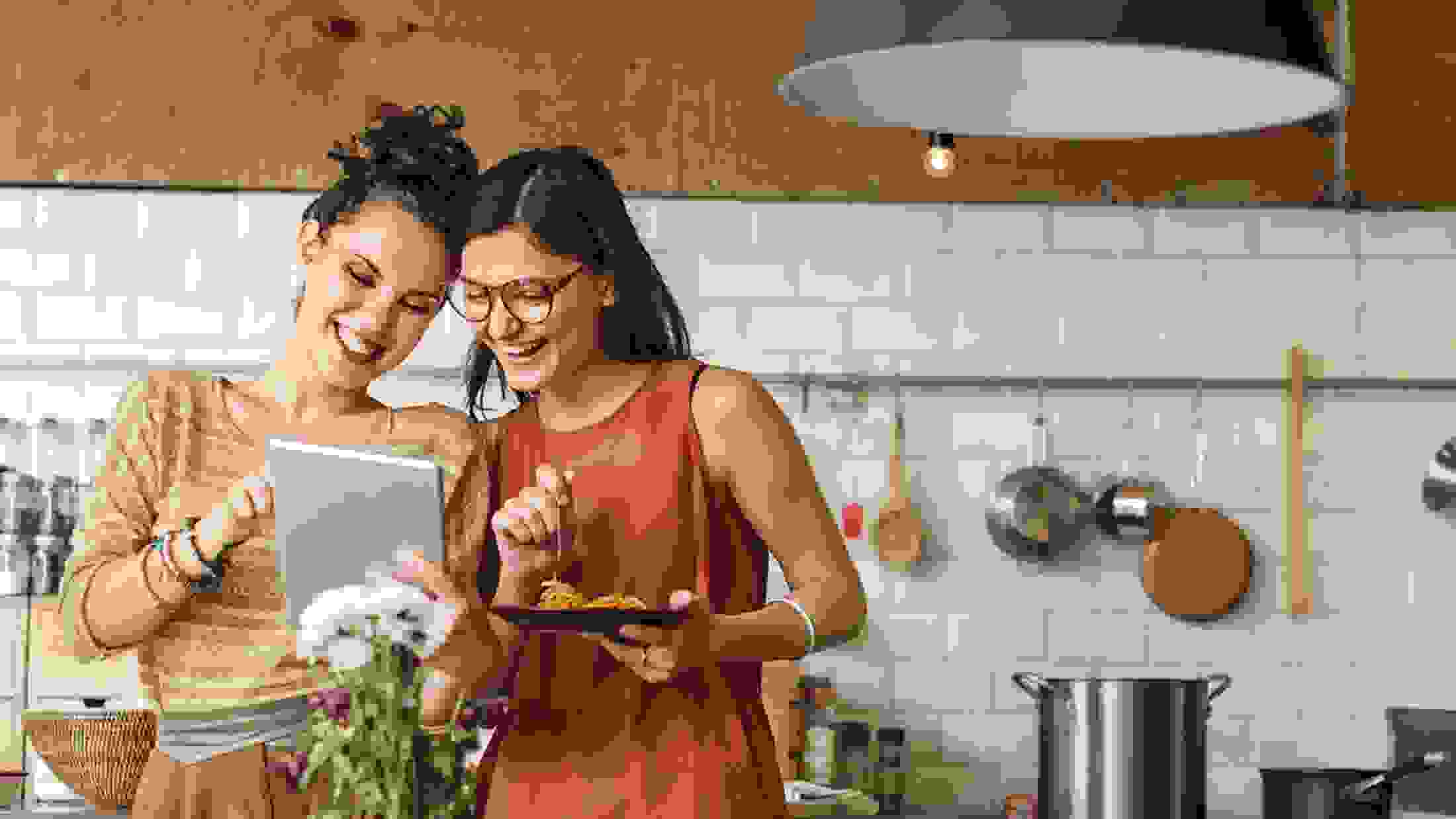 2 young ladies cooking in a kitchen at home