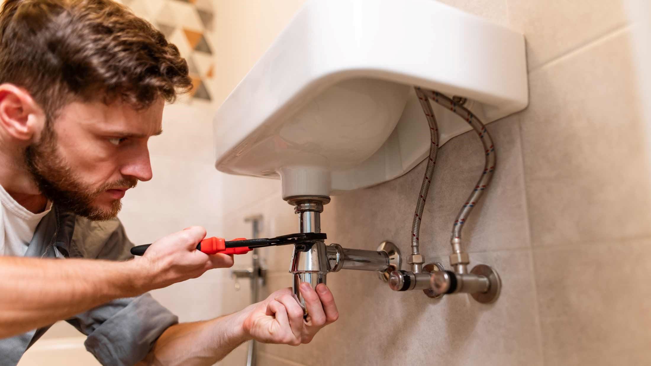 A plumber working to restore the functionality of a sink