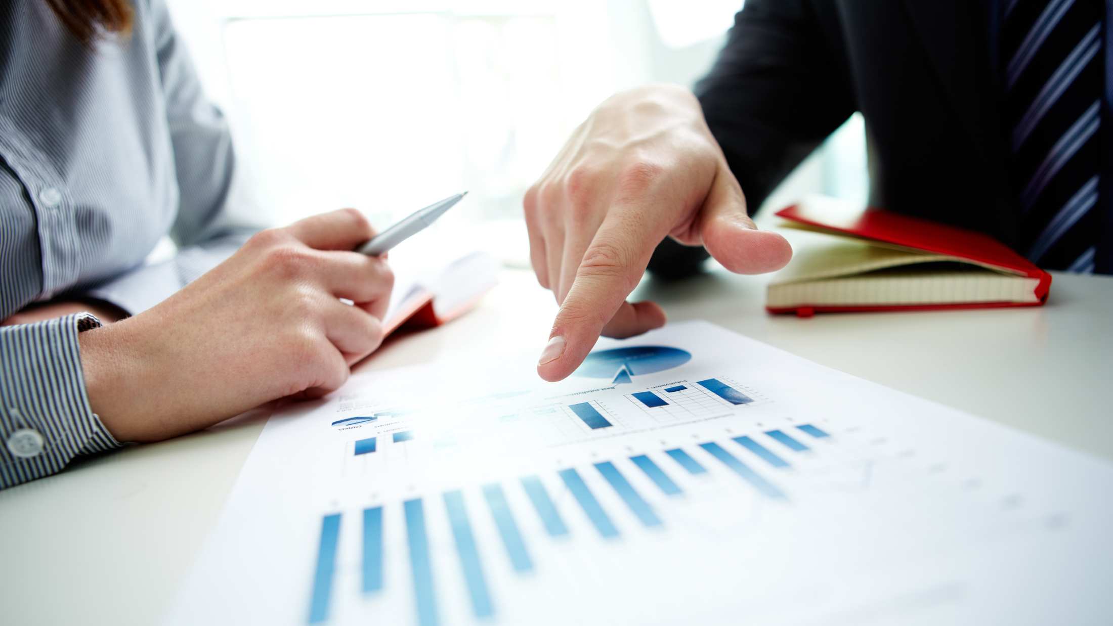 Male hands pointing at business document during discussion at meeting