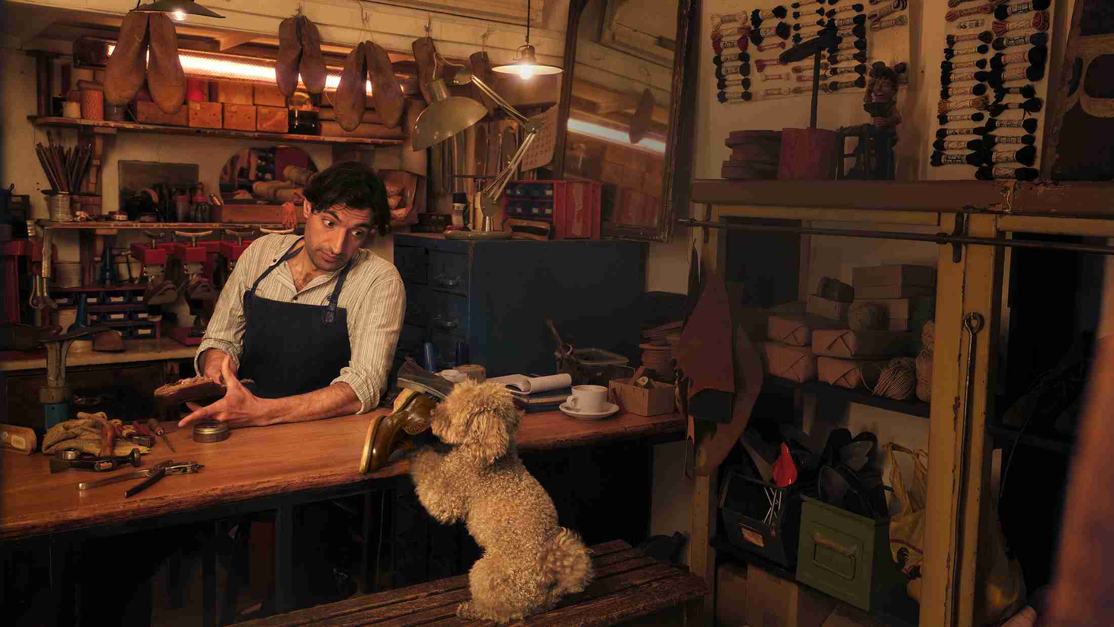 A cobbler operating his shop with the help of his dog