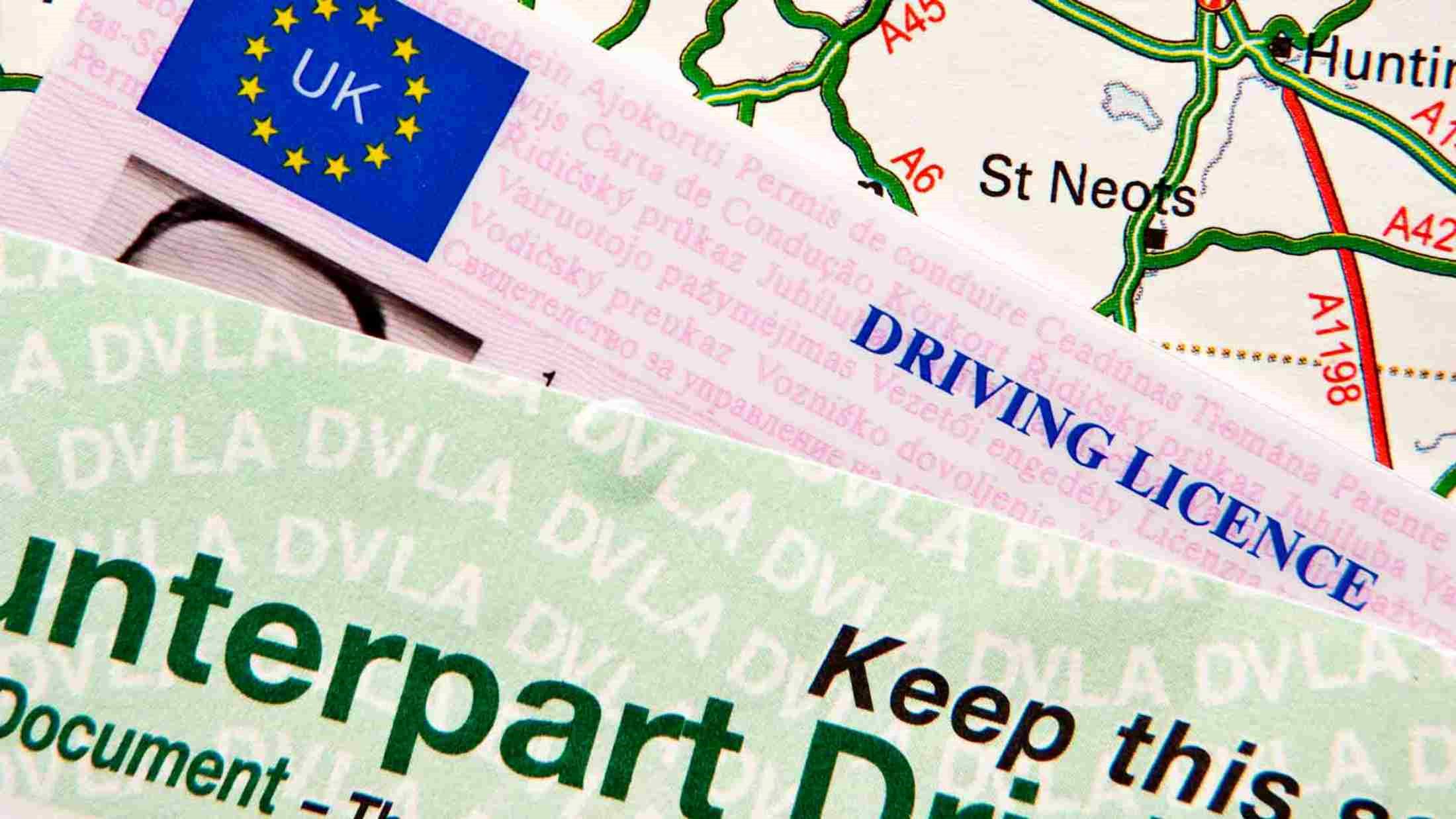 Driving licence and paper counterpart on top of a route map