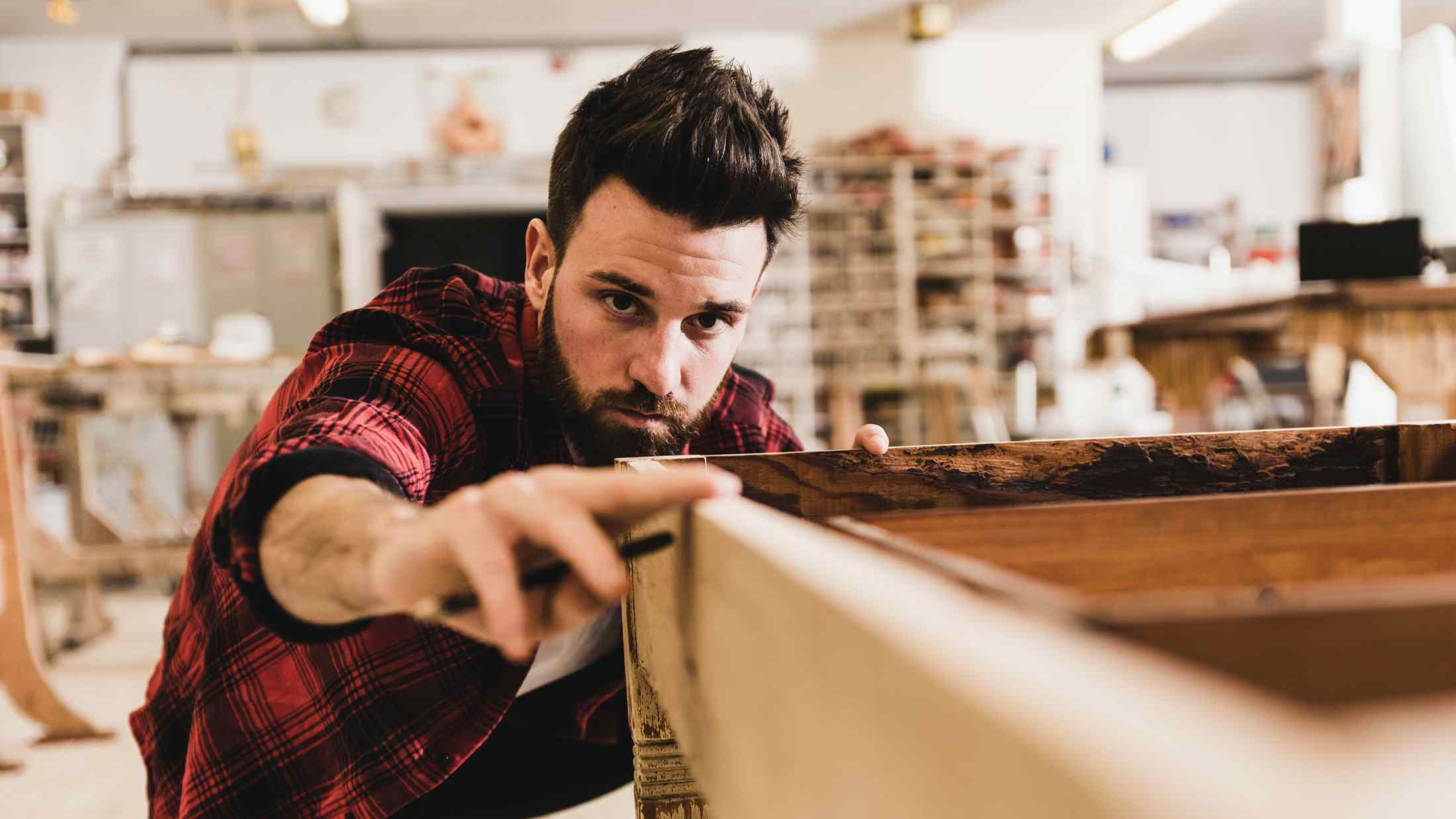 Craftsman examining wood in workshop