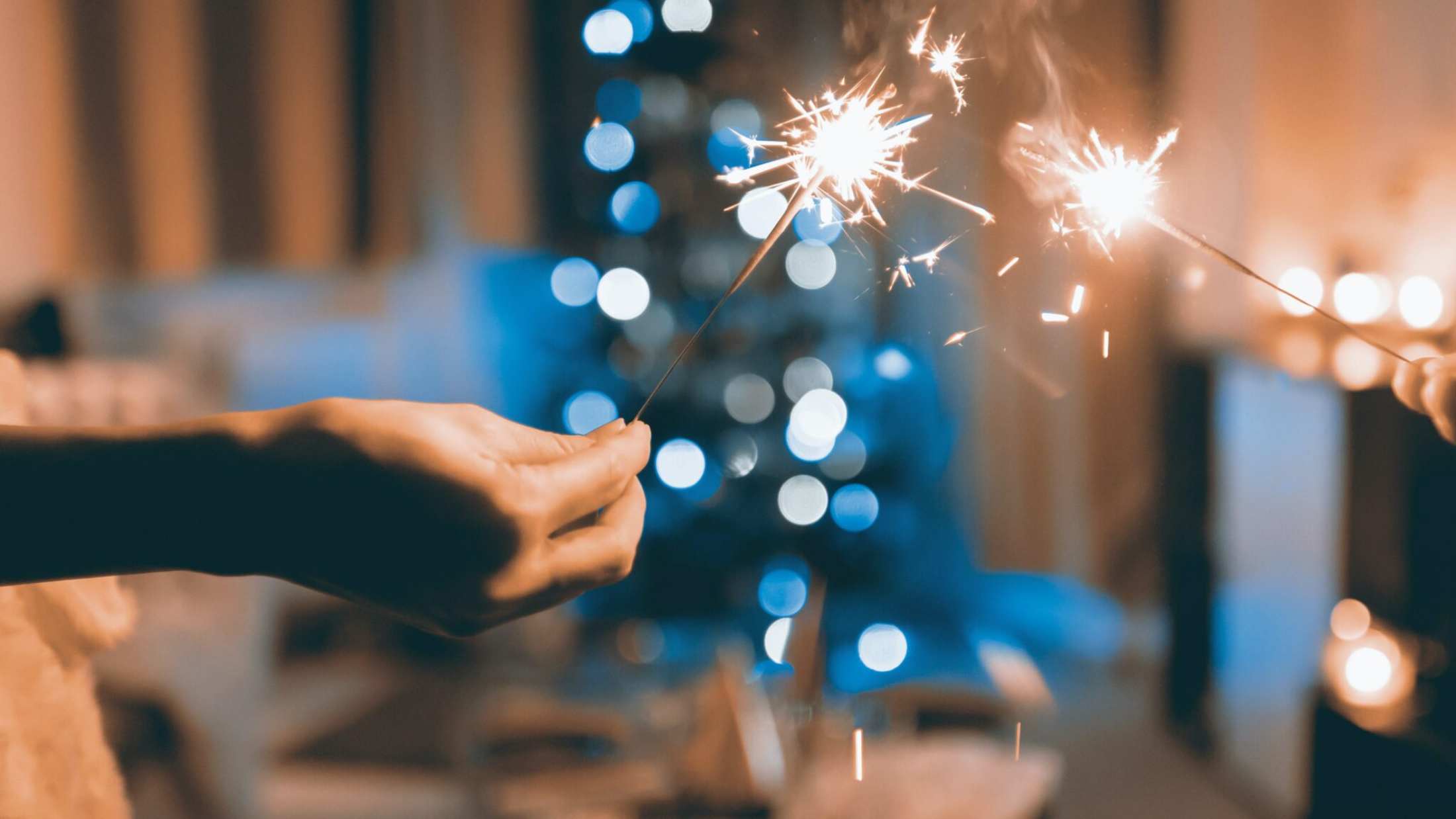 Two persons holding sparklers