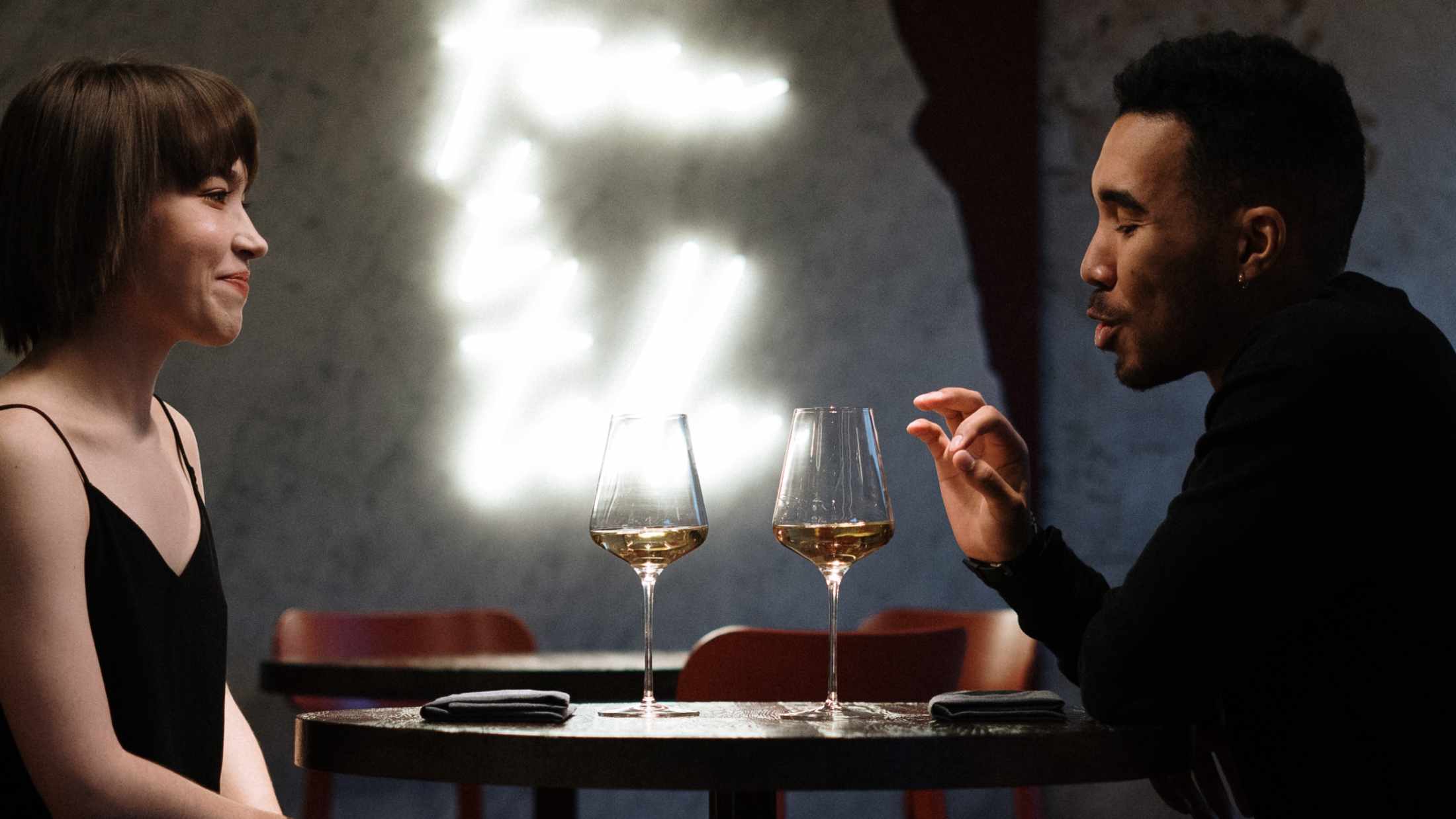 Man and woman sitting on chair in front of table in a restaurant on a date