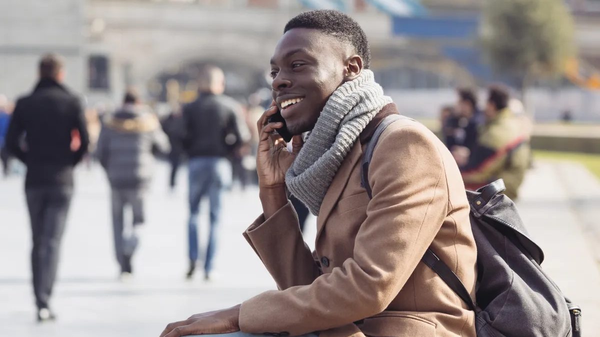Black male talking on phone while sat down