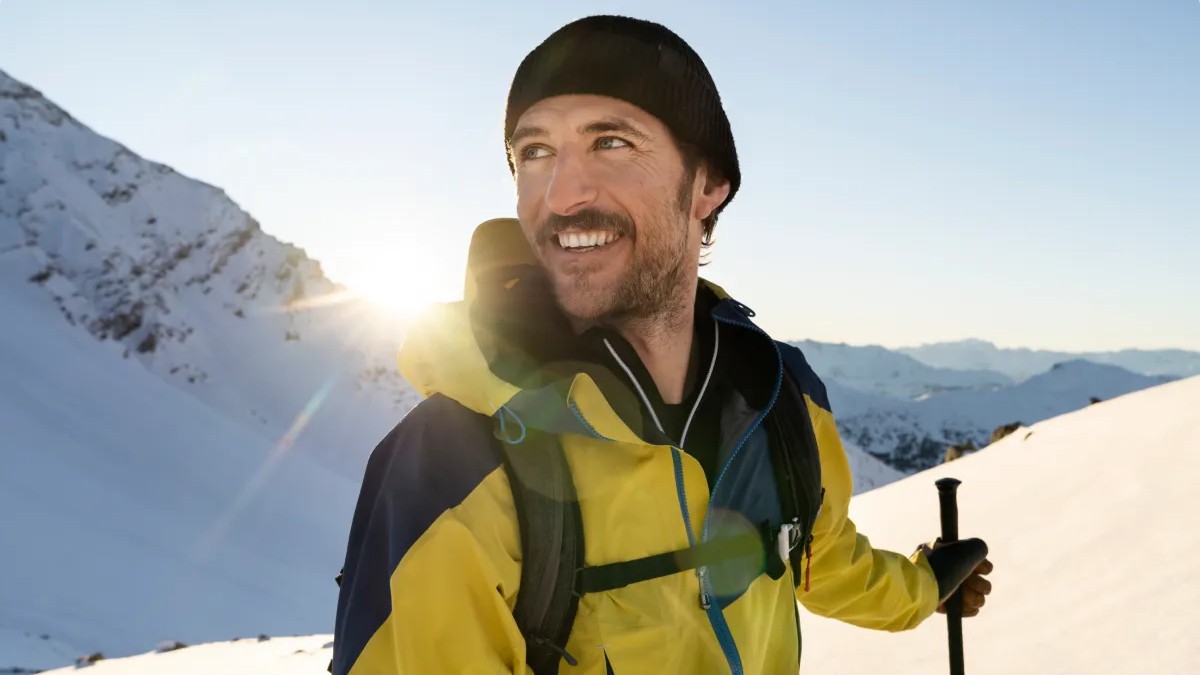 Man on a snowy mountain wearing a yellow jacket